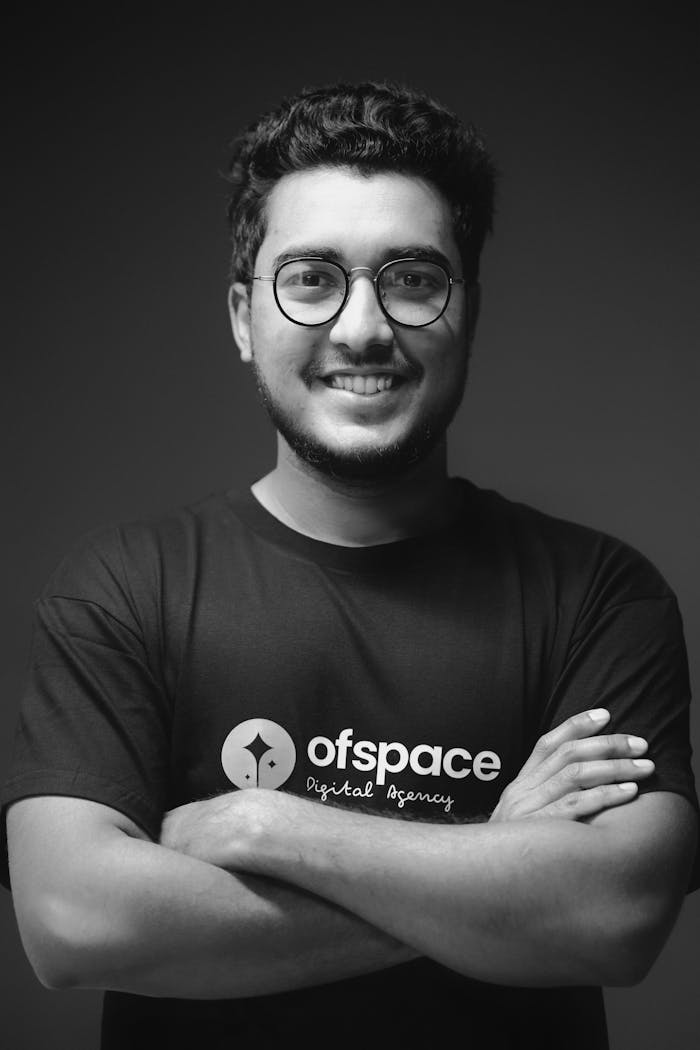 Crafting Captivating Headlines: Your awesome post title goes here Studio portrait of a smiling young man with eyeglasses in black and white.